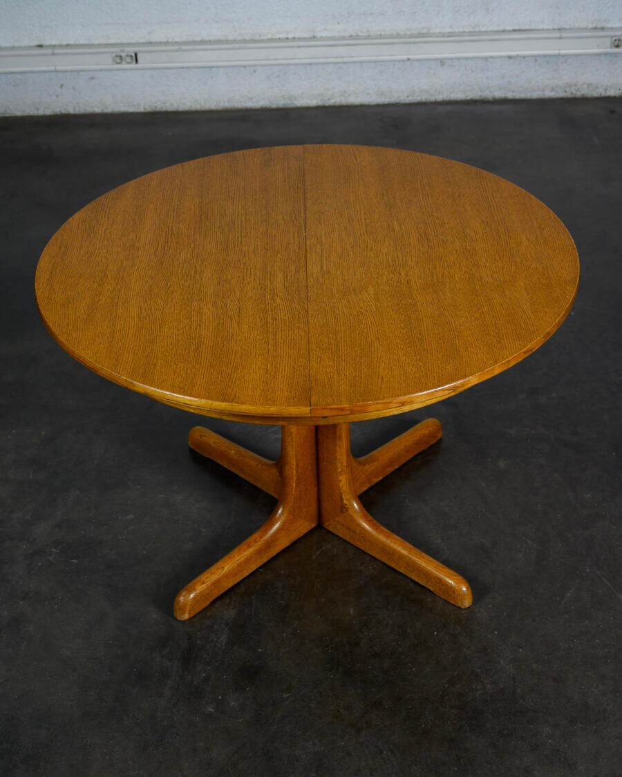 Round teak table with an extension.