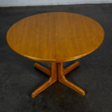 Round teak table with an extension.