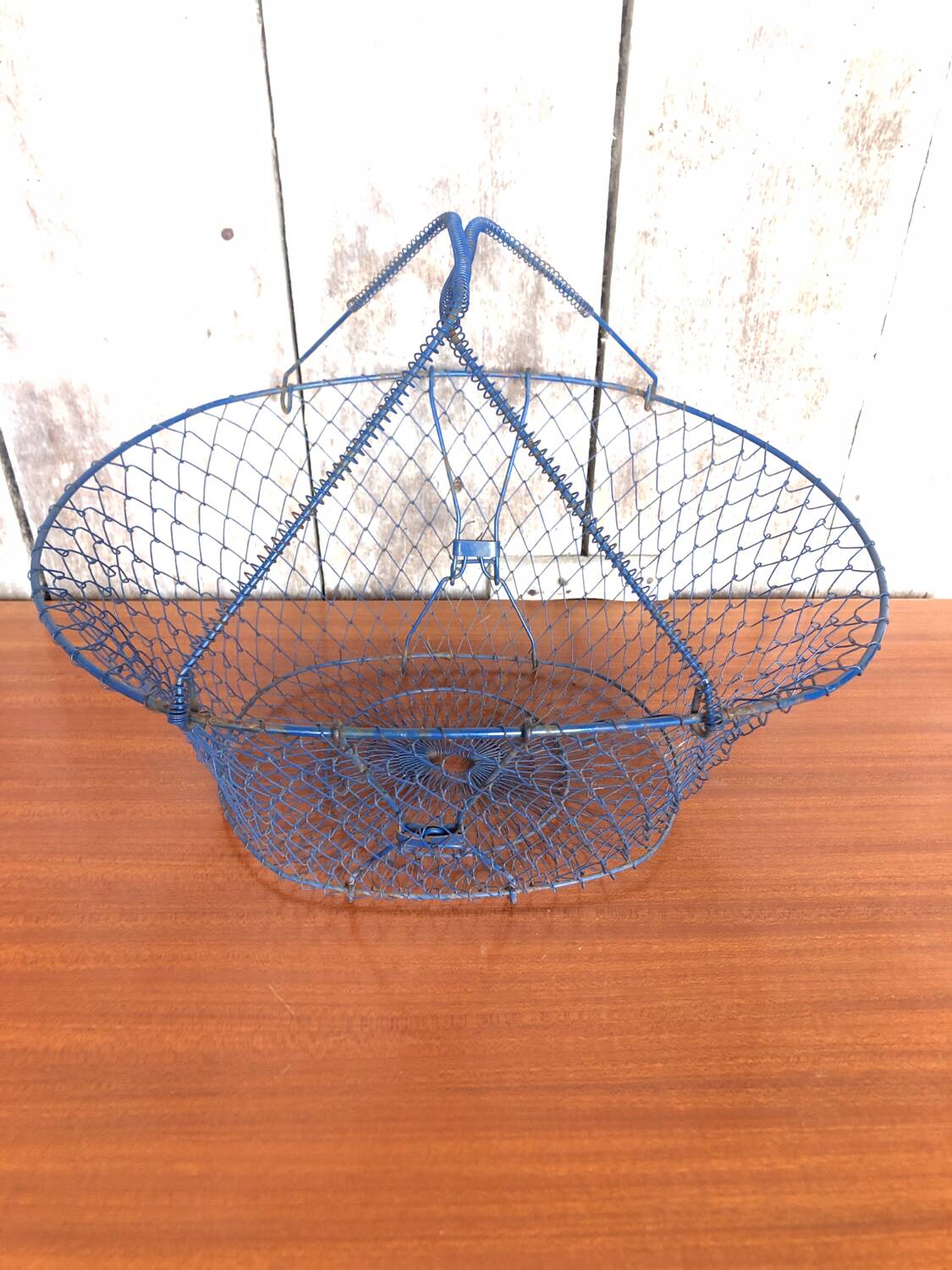 Old foldable blue metal basket, vintage handles