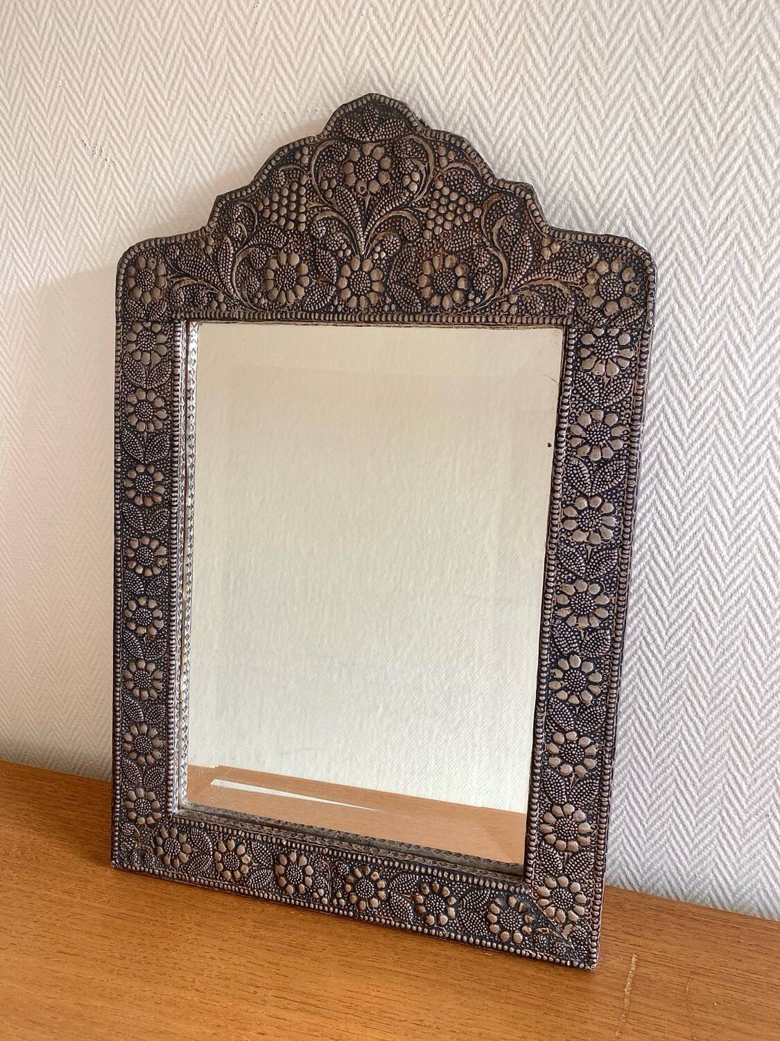 Ancient oriental mirror in embossed copper