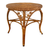 Round coffee table in rattan and woven wicker, with a scroll design.