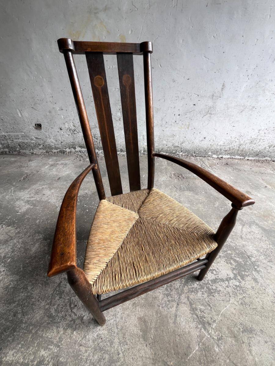 Dark brown solid wood Arts & Crafts armchair with natural rush seat and high back
