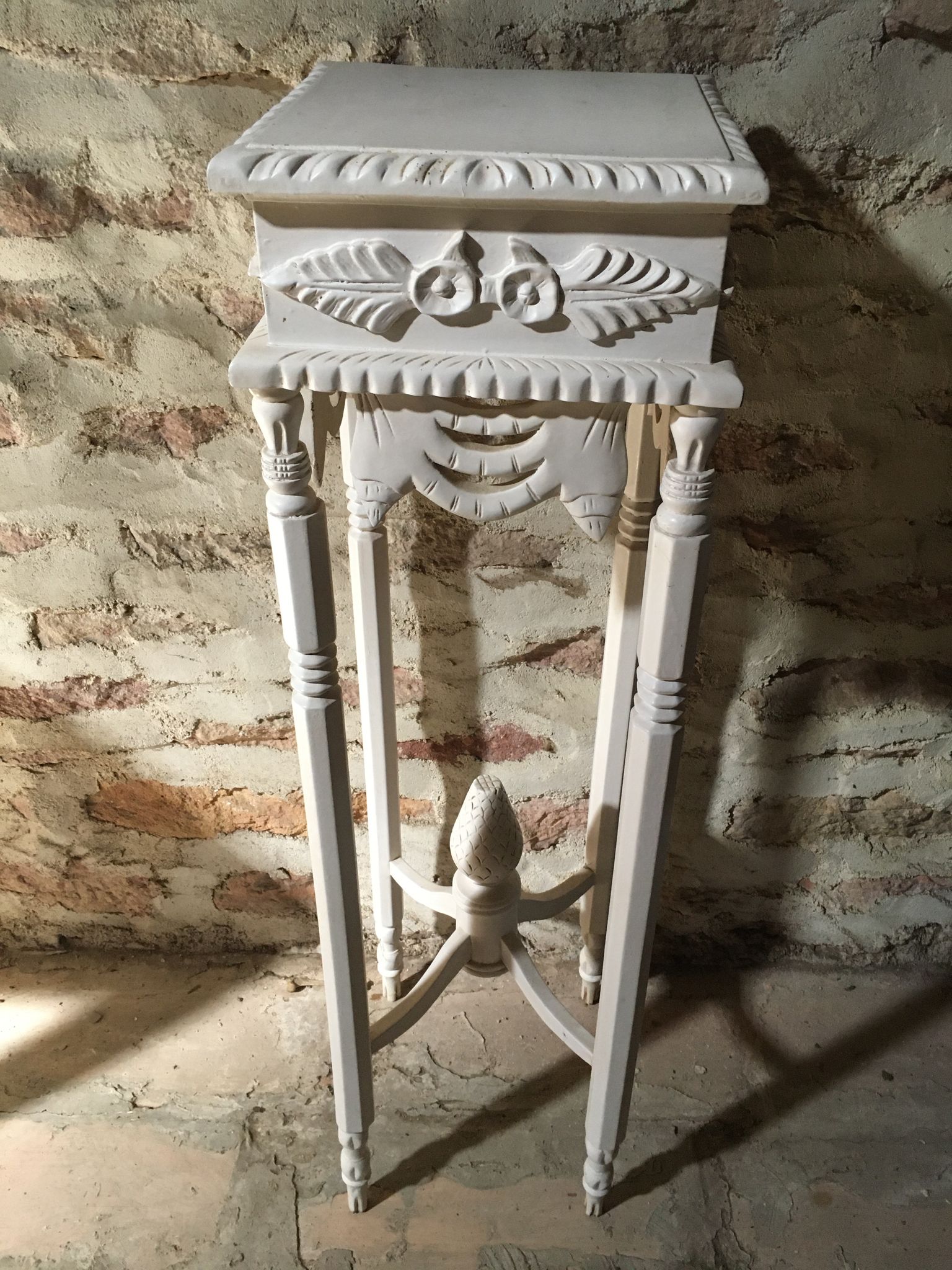 Carved wooden stool with a white patina.