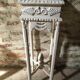 Carved wooden stool with a white patina.