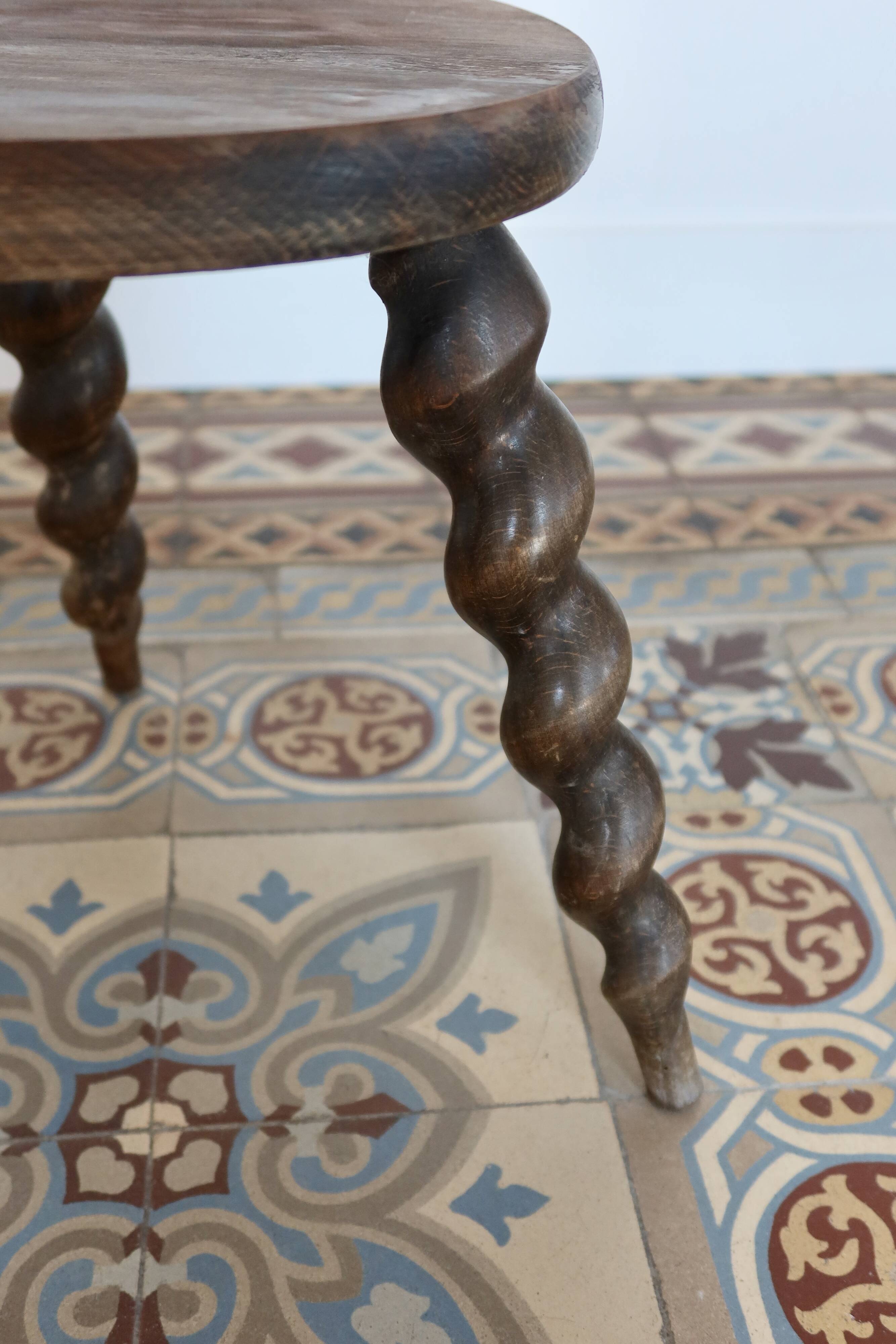 Antique tripod stool made of turned wood.
