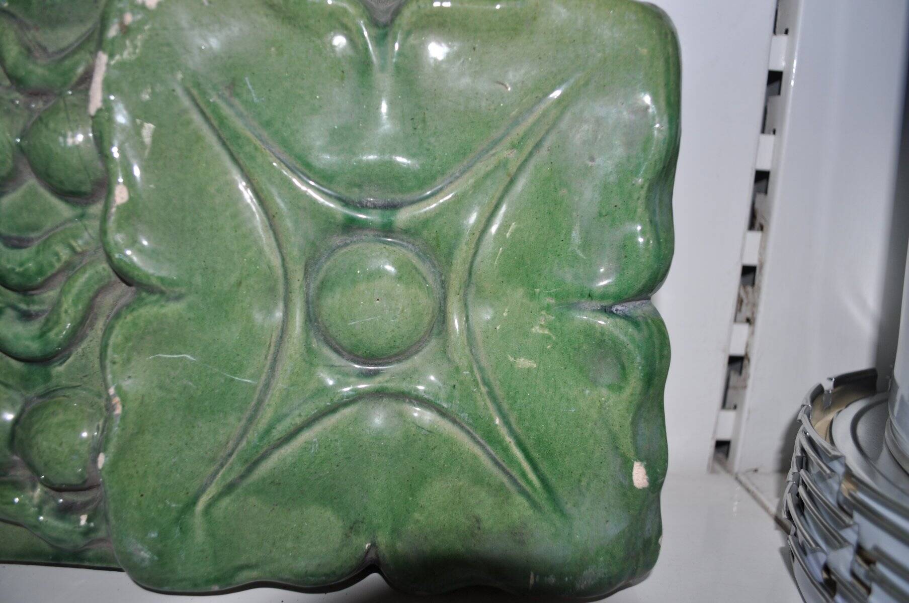 Green enamelled ceramic stove tile — finely sculpted Hungarian pattern from the late 19th century.