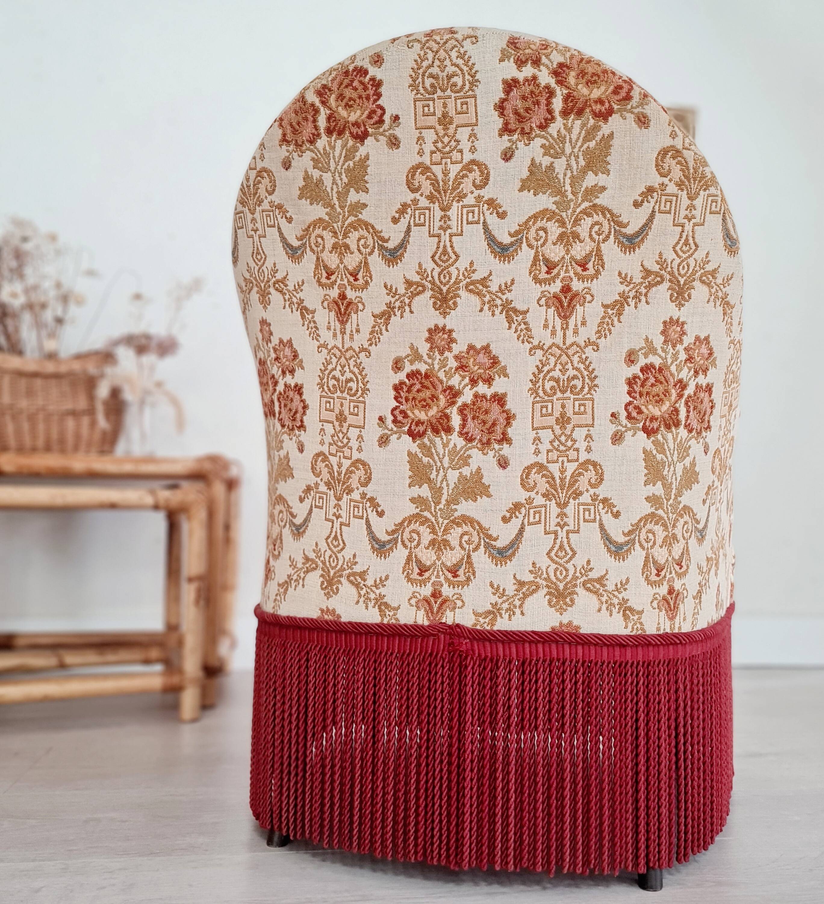Beige toad armchair with floral patterns and red fringes