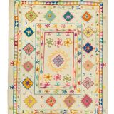White suzani kilim rug with multi-colored embroidered patterns