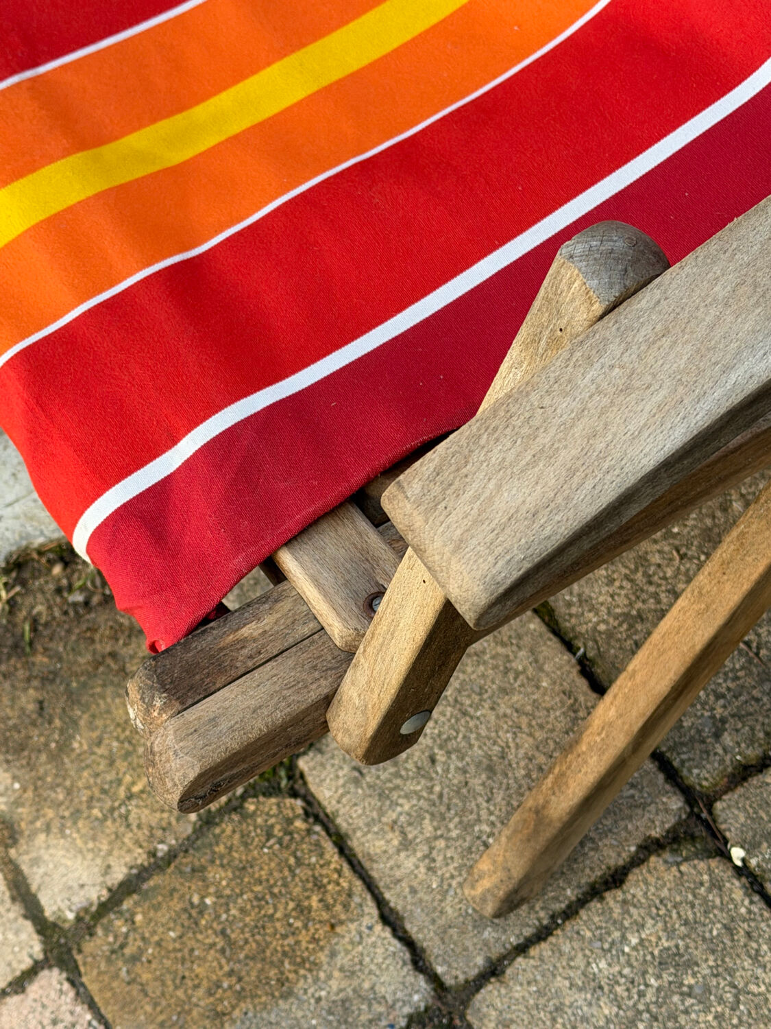Vintage deck chair with red and orange striped fabric, original patina.