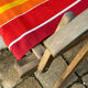 Vintage deck chair with red and orange striped fabric, original patina.