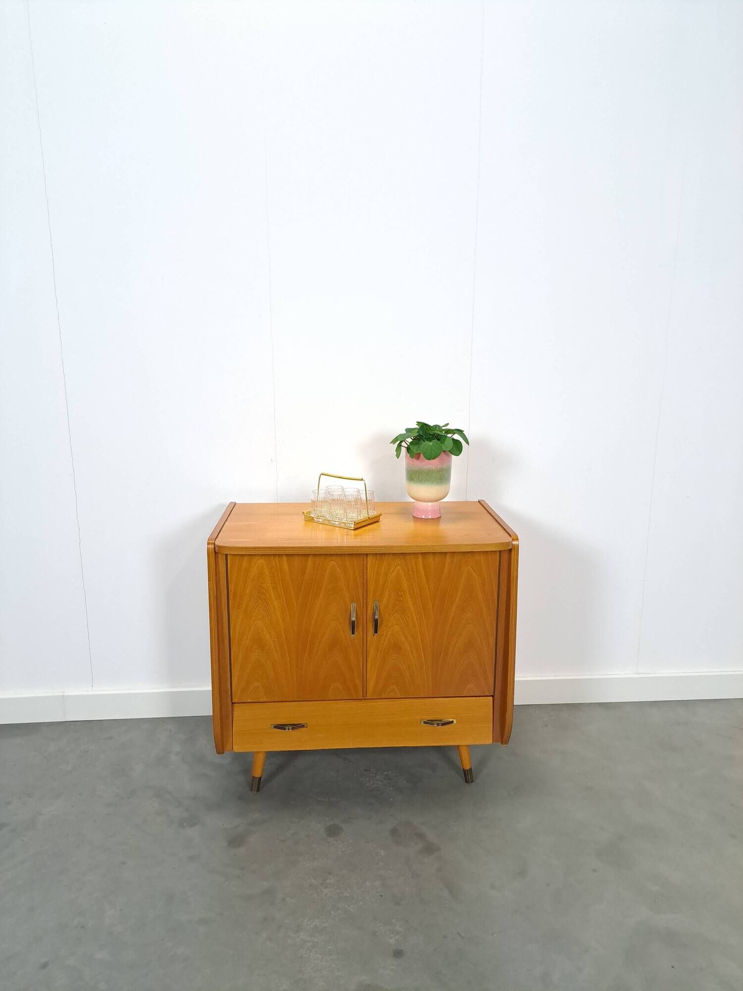 Meuble TV audio avec poignées en laiton et pieds inclinés.