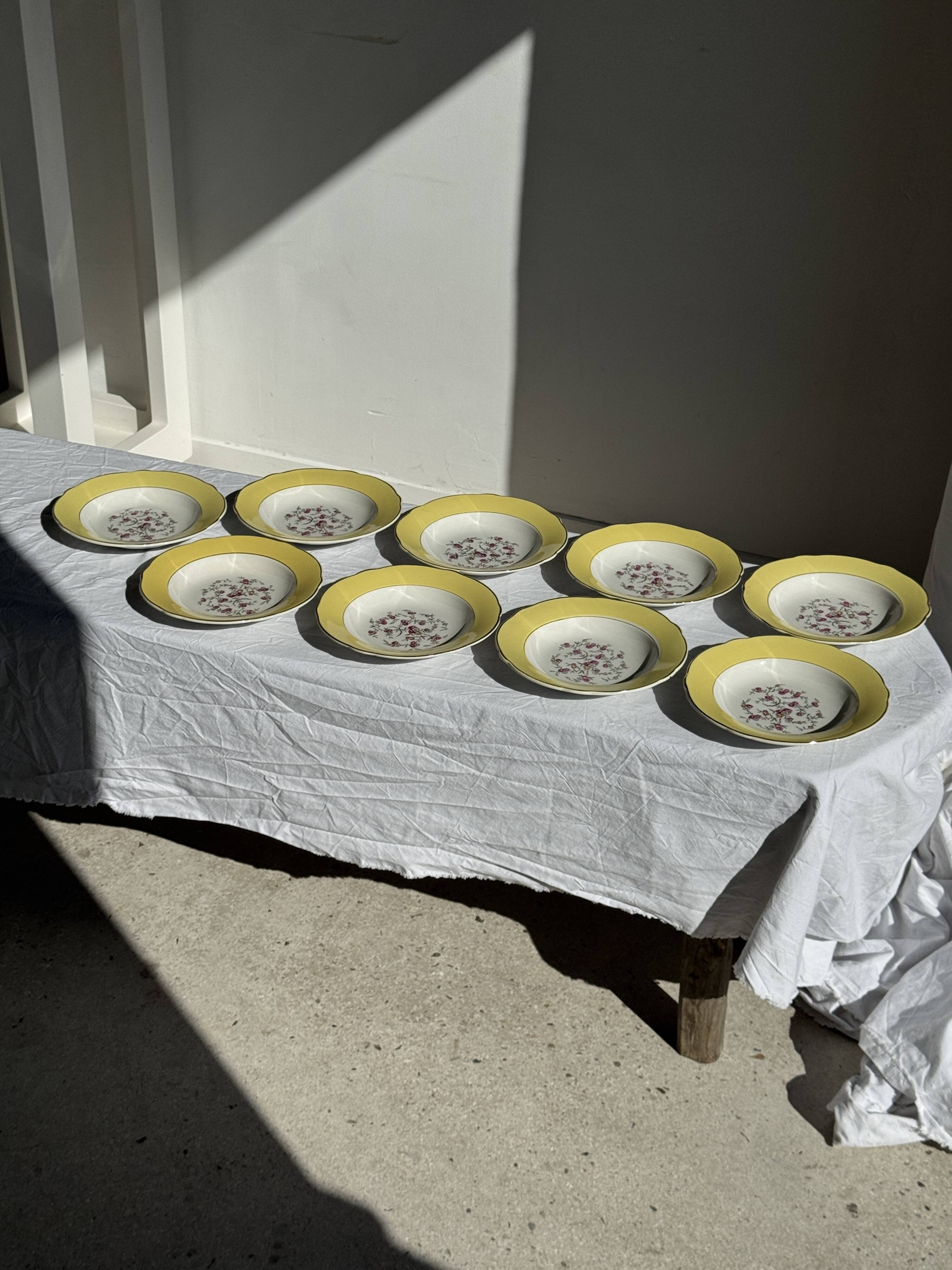Set of 9 large vintage yellow deep plates with pink flowers and a gold rim.