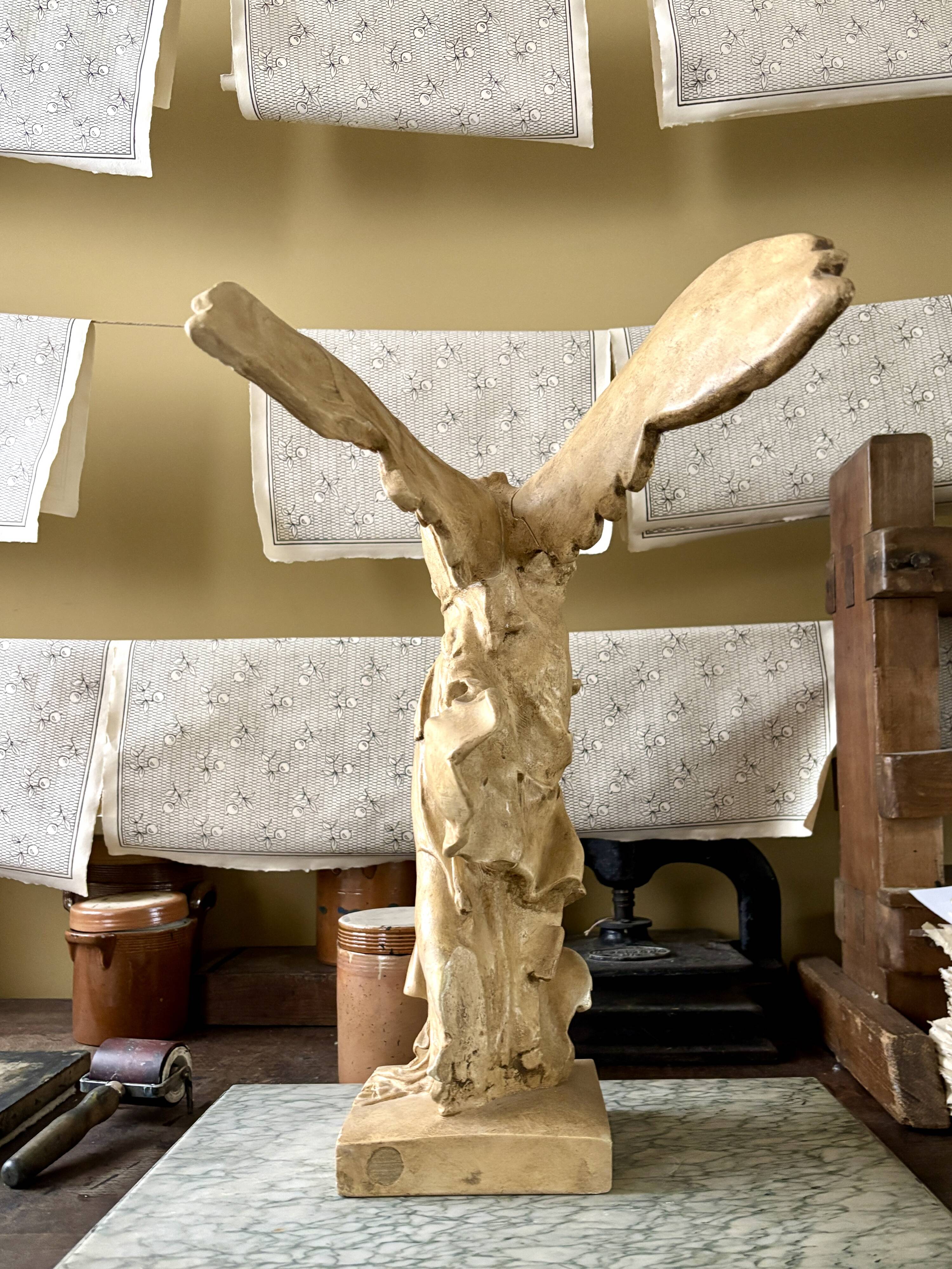 "Winged Victory of Samothrace", beige plaster statuette