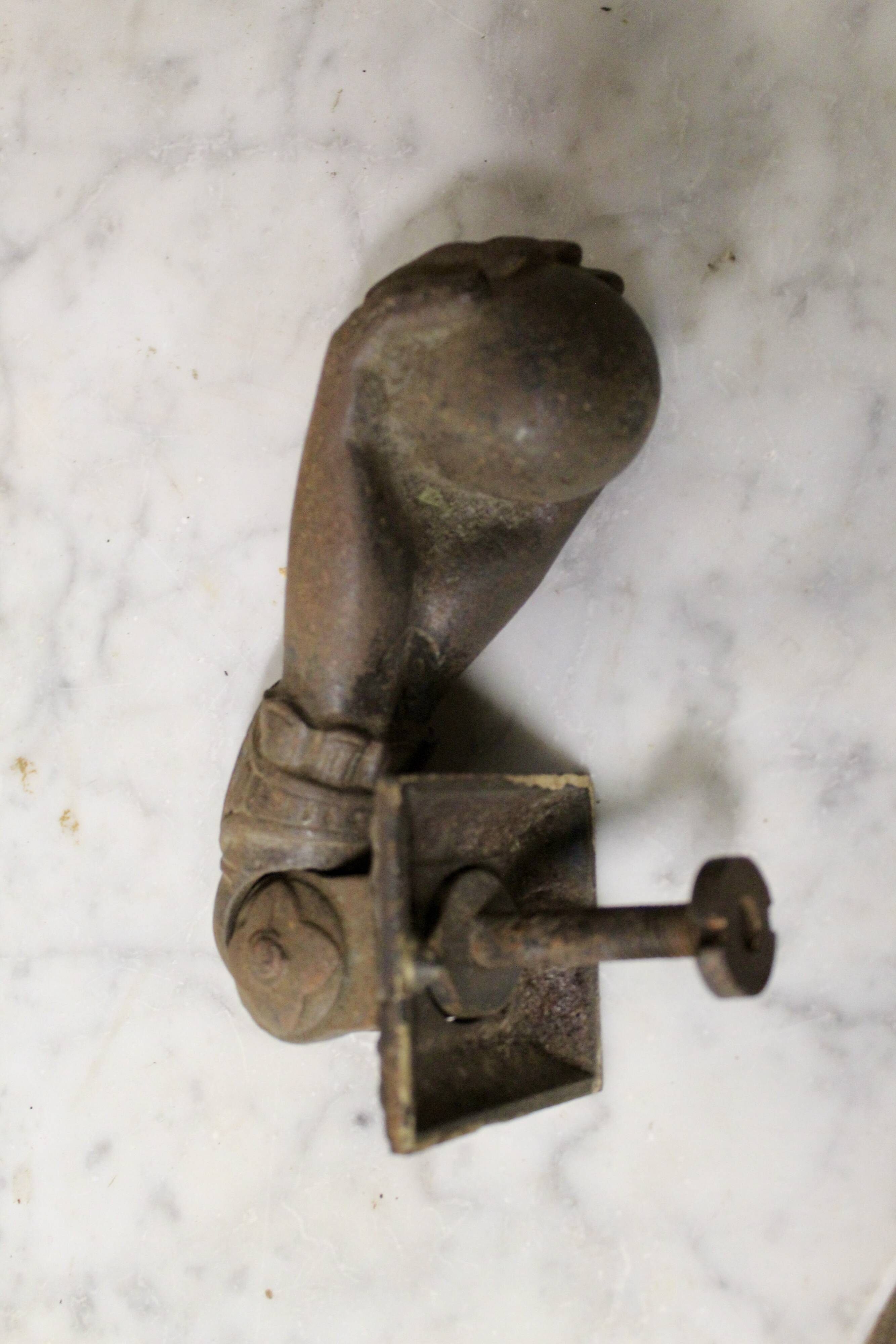 Antique cast iron door knocker in the shape of a 19th century hand