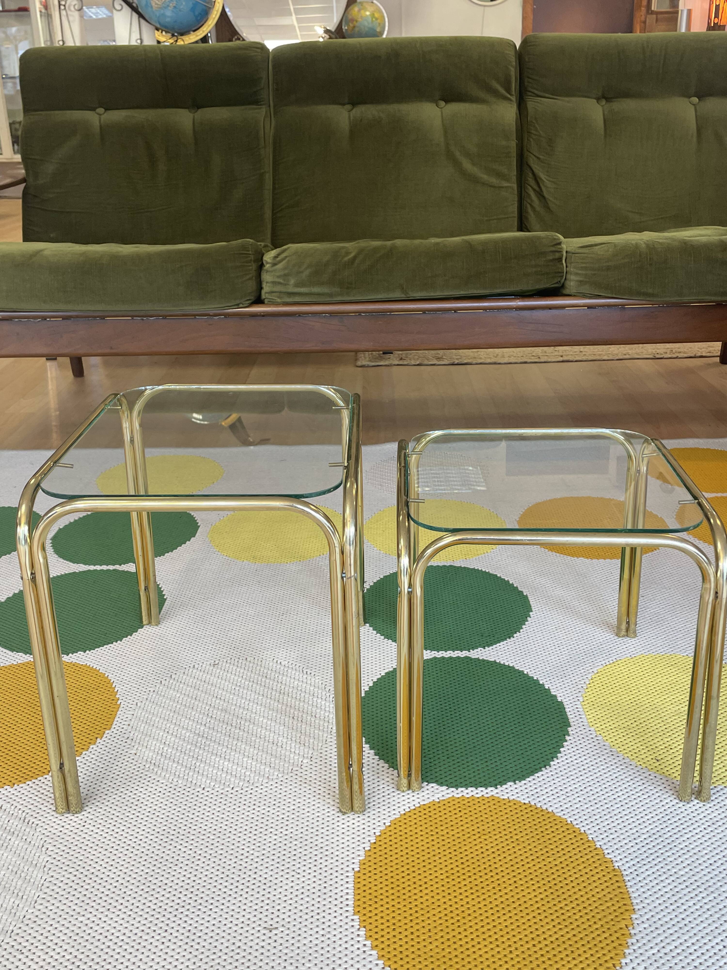 Pair of small nesting coffee tables in gold tubular metal & transparent glass tops