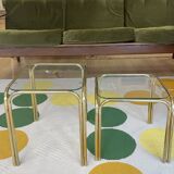 Pair of small nesting coffee tables in gold tubular metal & transparent glass tops