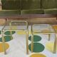 Pair of small nesting coffee tables in gold tubular metal & transparent glass tops