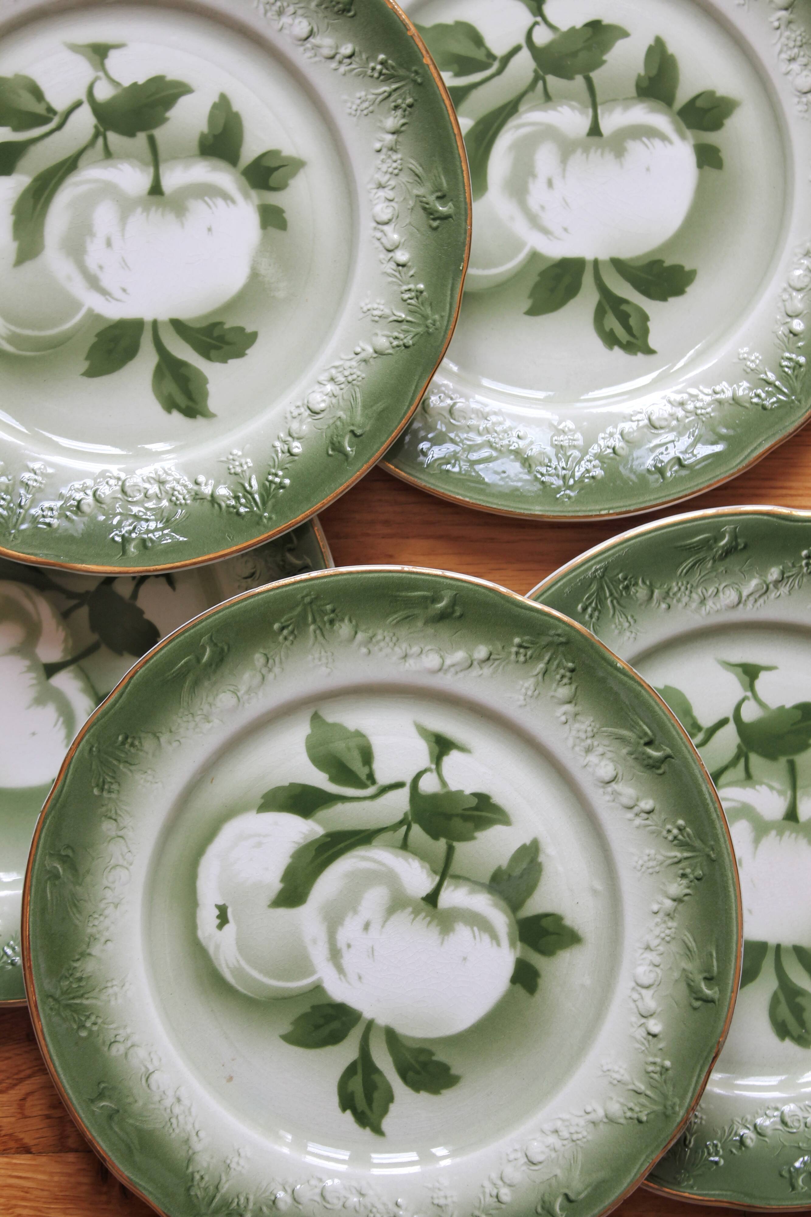 7 earthenware dessert plates with apple decoration and slip-brushed rim, KG Lunéville