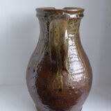 Old pitcher in brown sandstone with green drippings