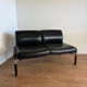 Vintage 2-seater banquette in black faux leather – 1980s