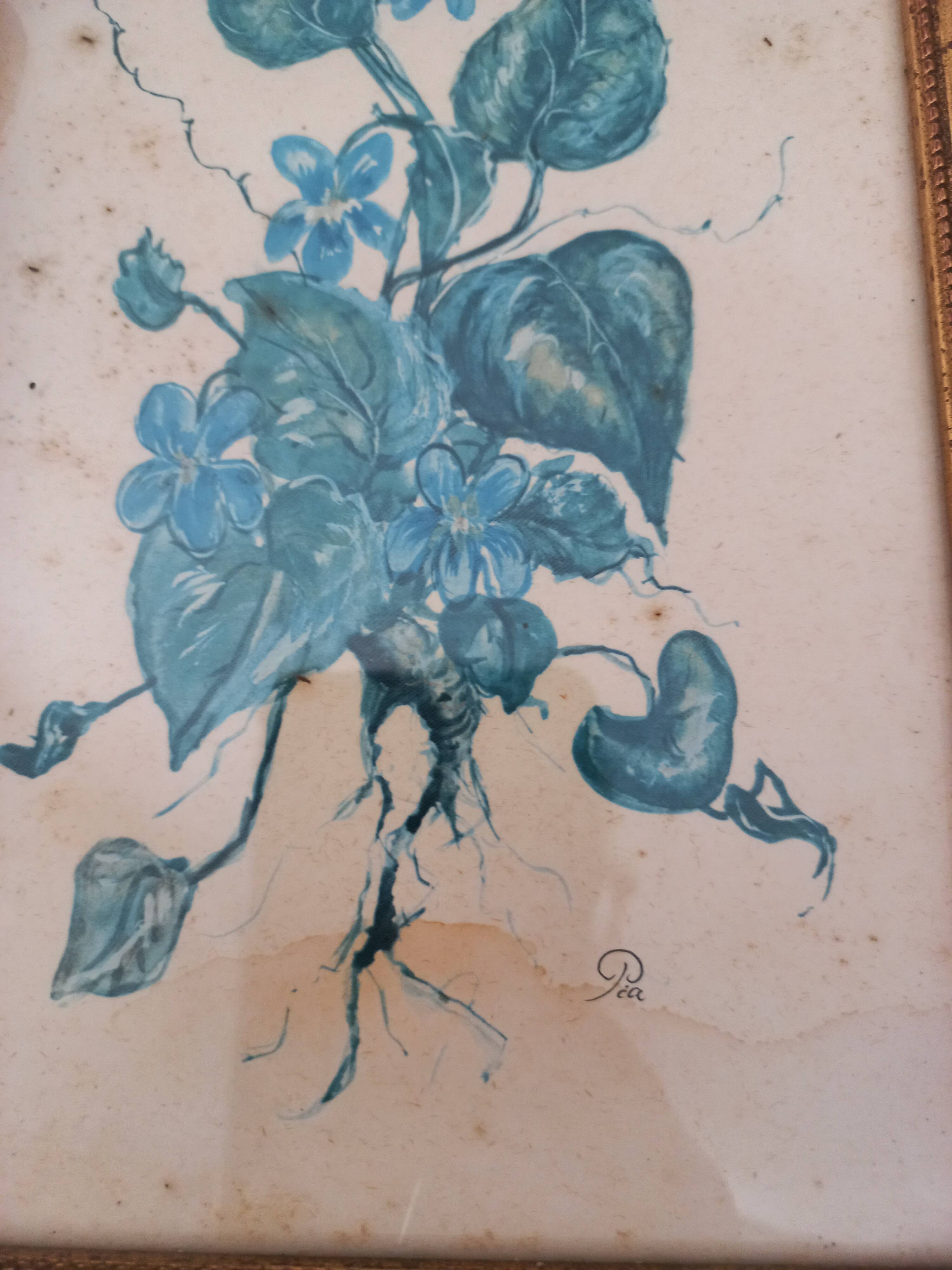 Decorative table with vintage blue flowers in a golden frame.