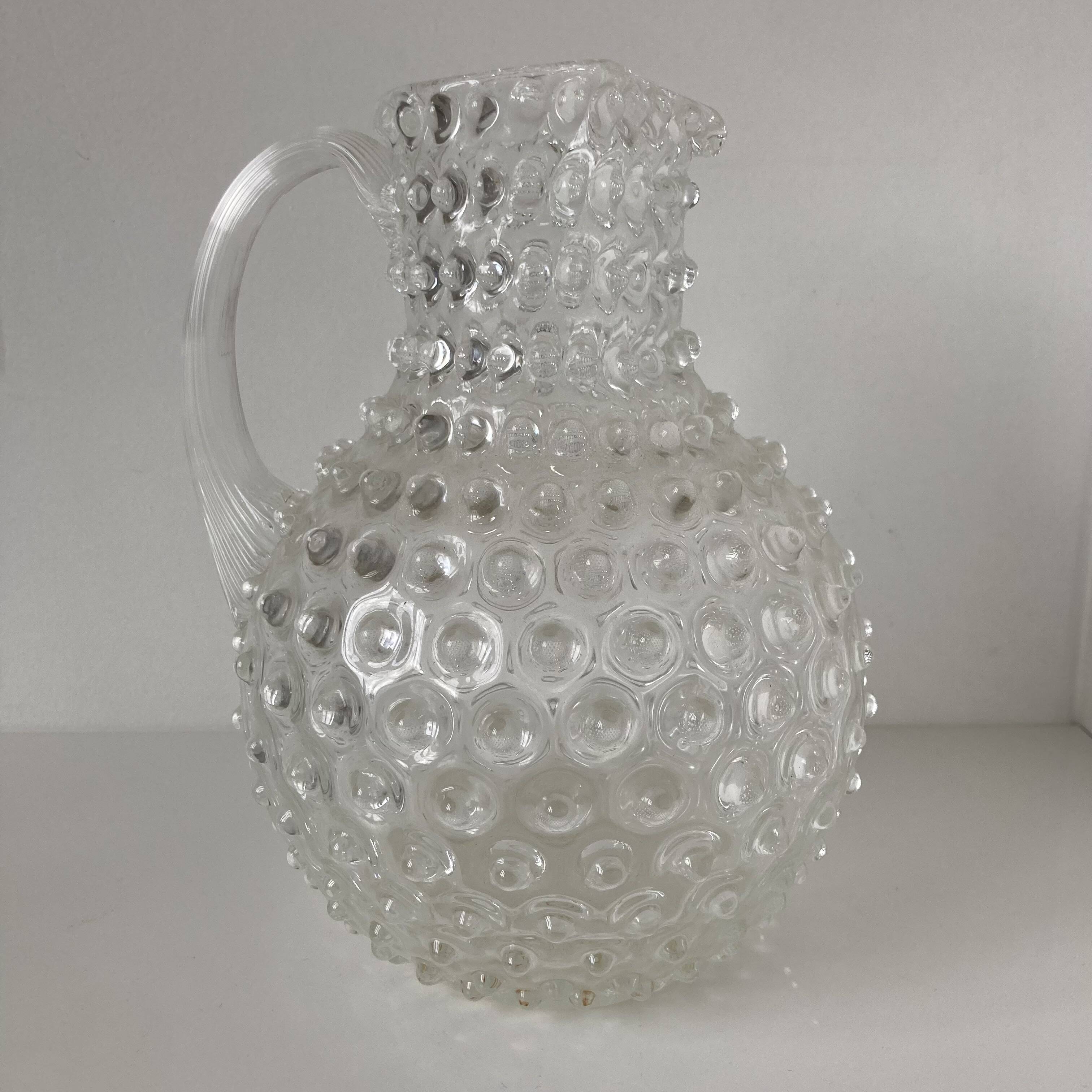 Beautiful and large vintage glass jug with a handle, made of clear hot-worked glass.