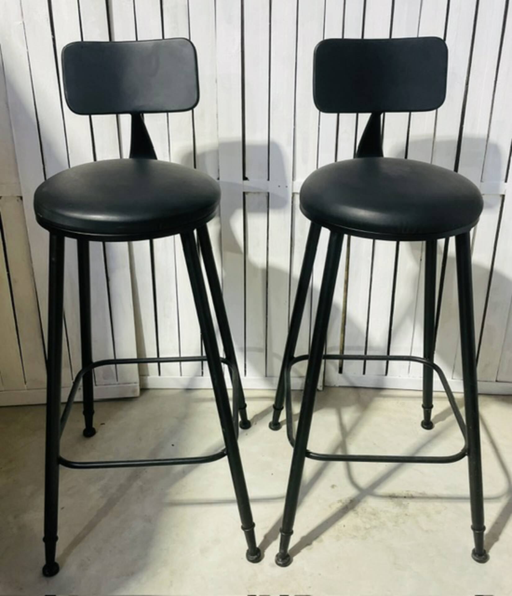 Pair of black bar stools in industrial and contemporary style.
