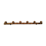 Old rustic wooden coat rack turned in imitation of bamboo