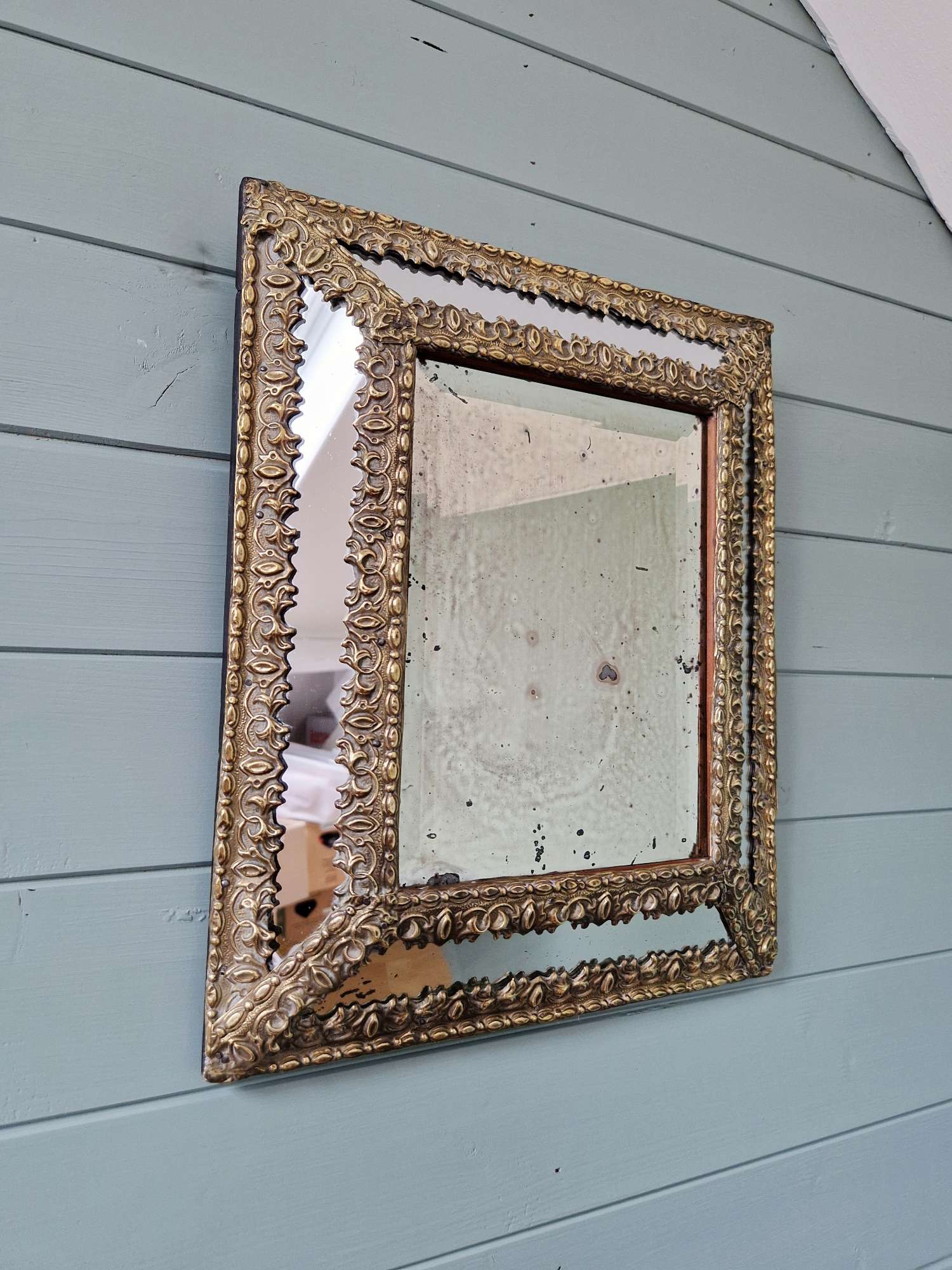 Mirror with repoussé brass frame, mercury glass, 19th century.