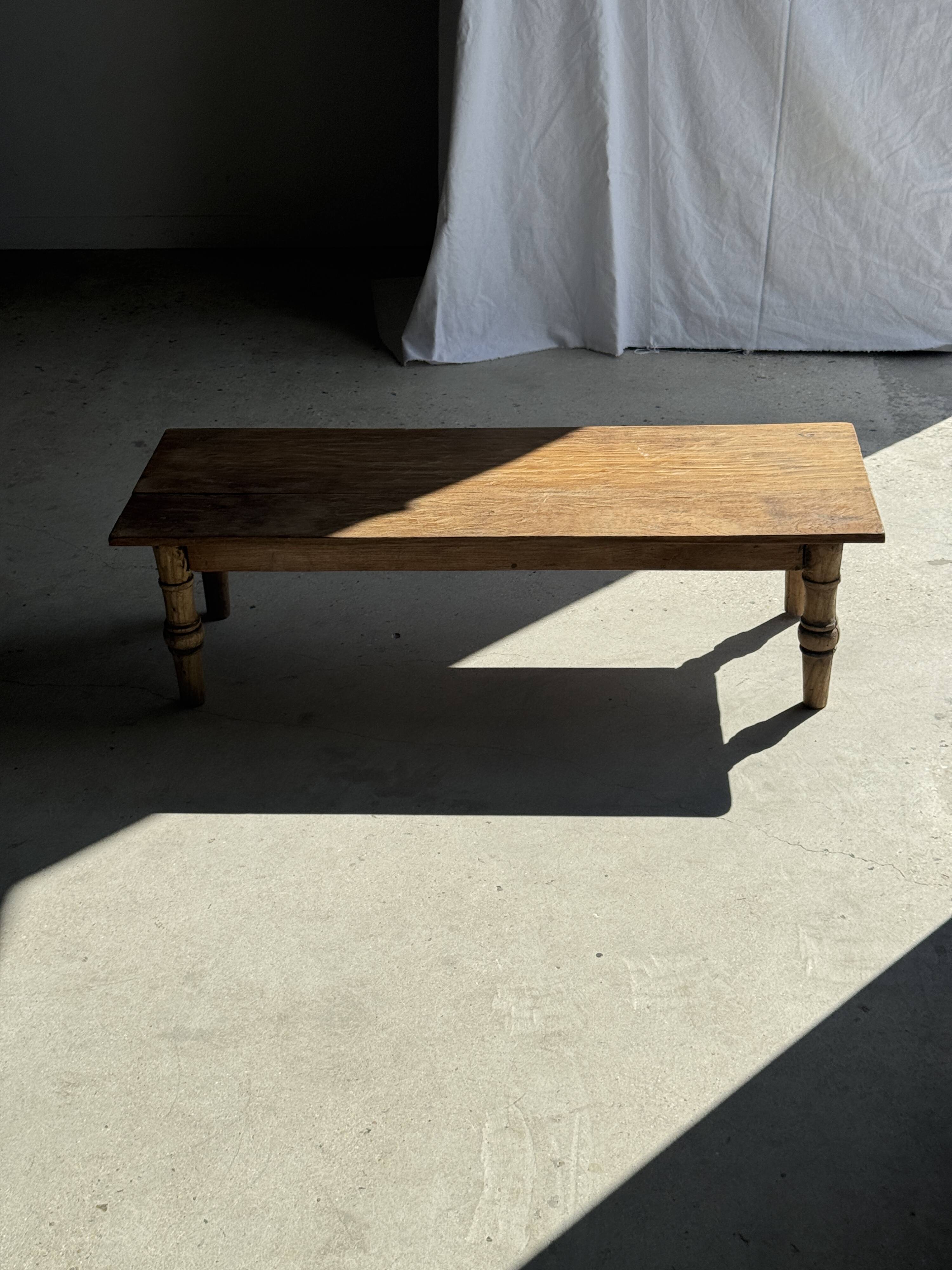 Brown Indonesian teak coffee table, with a border and cylindrical legs H40 L103.