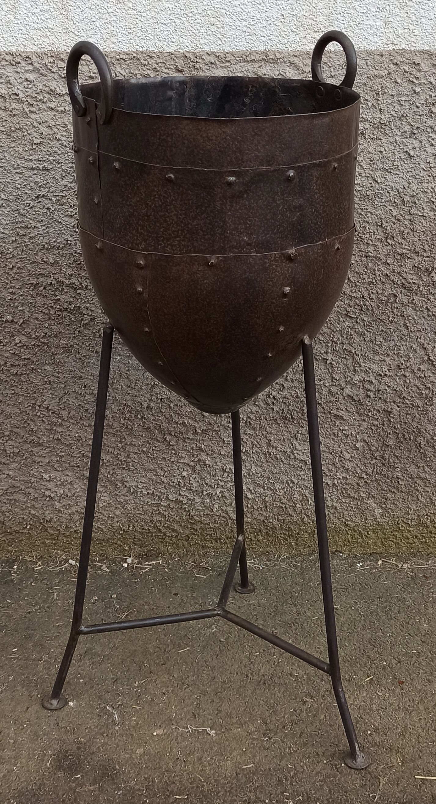 Old metal pot on foot