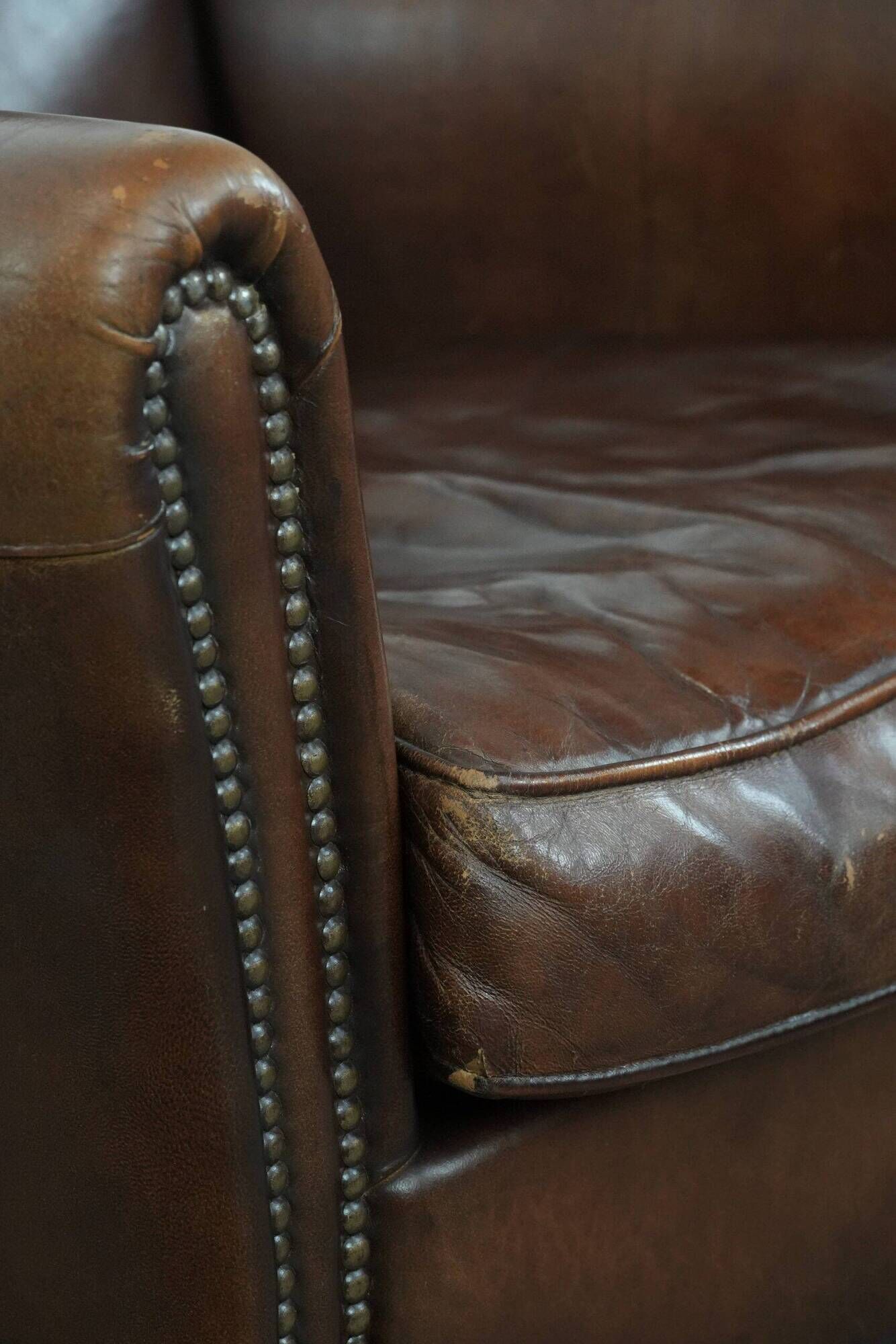Ensemble de deux fauteuils en cuir de mouton vintage au caractère marqué.