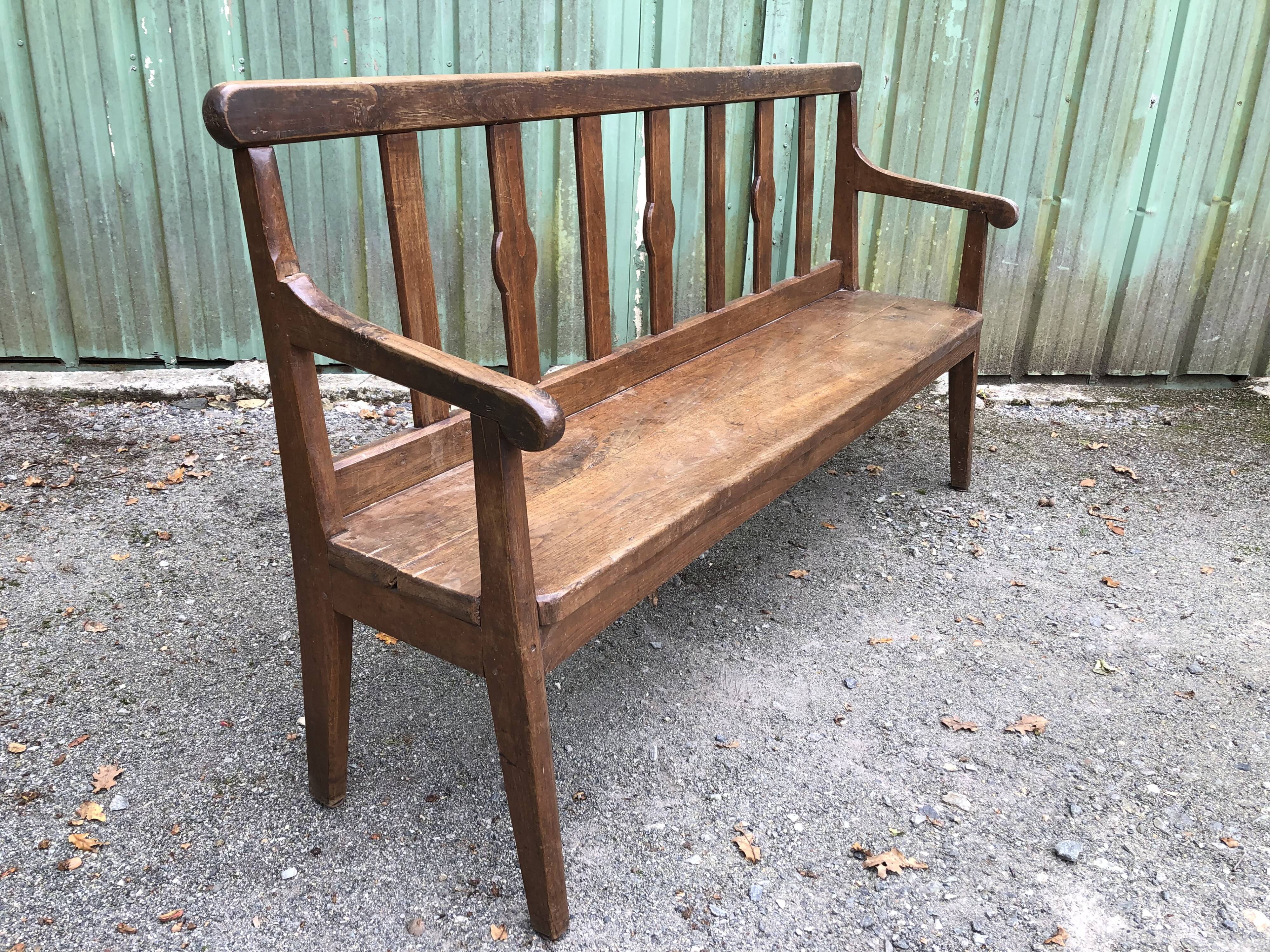 Duo of old solid oak benches with backs and armrests.