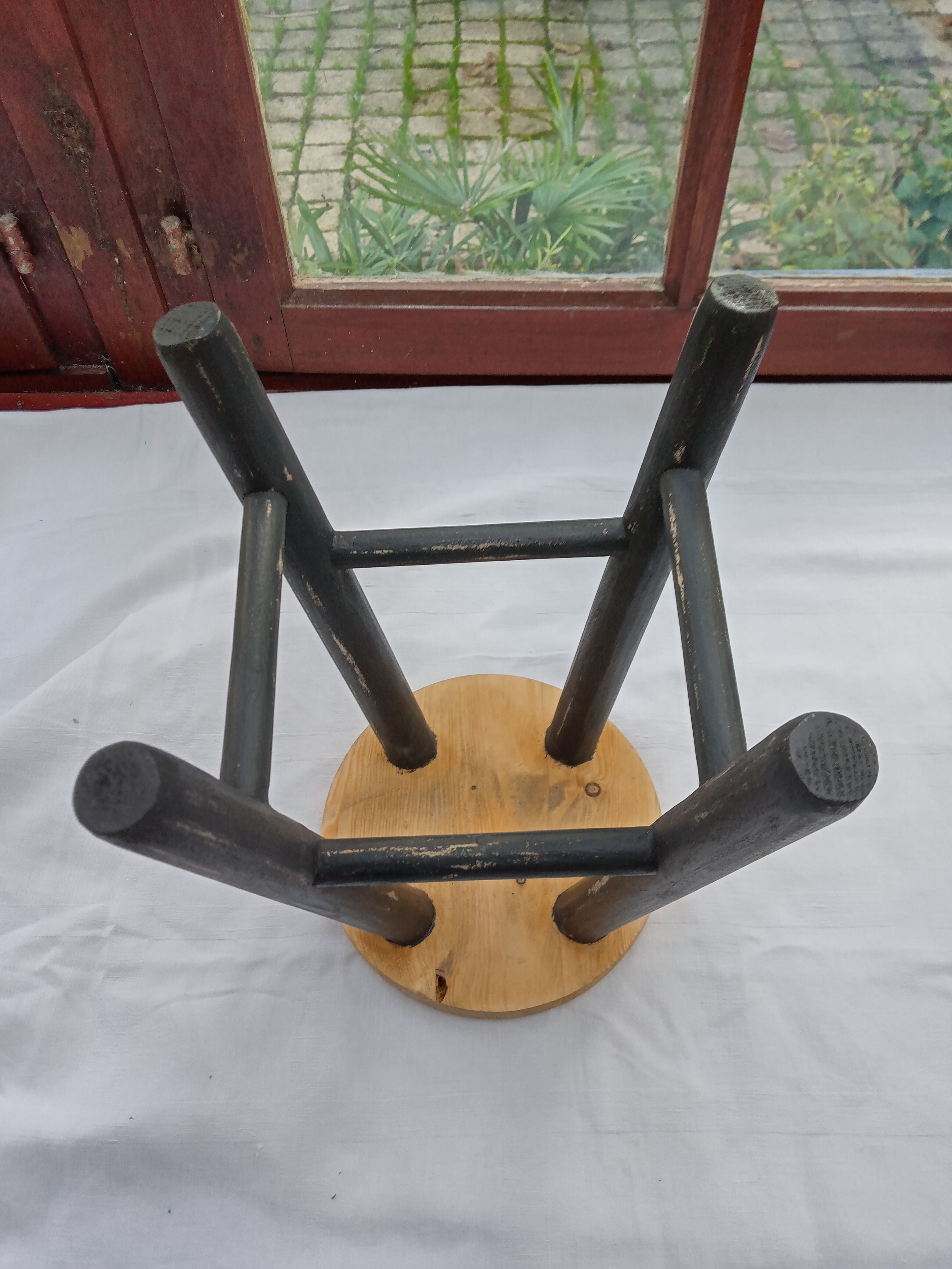 Low wooden stool and black patina