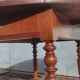 Table ronde ancienne extensible en bois fruitier avec côtés rabattables