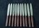 Box of 10 vintage knives with brown Bakelite handles.