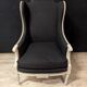 Paire de fauteuils Louis XVI à oreillettes en bois peint gris et tissu noir