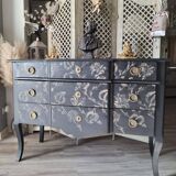 Large black chest of drawers with golden floral decoration