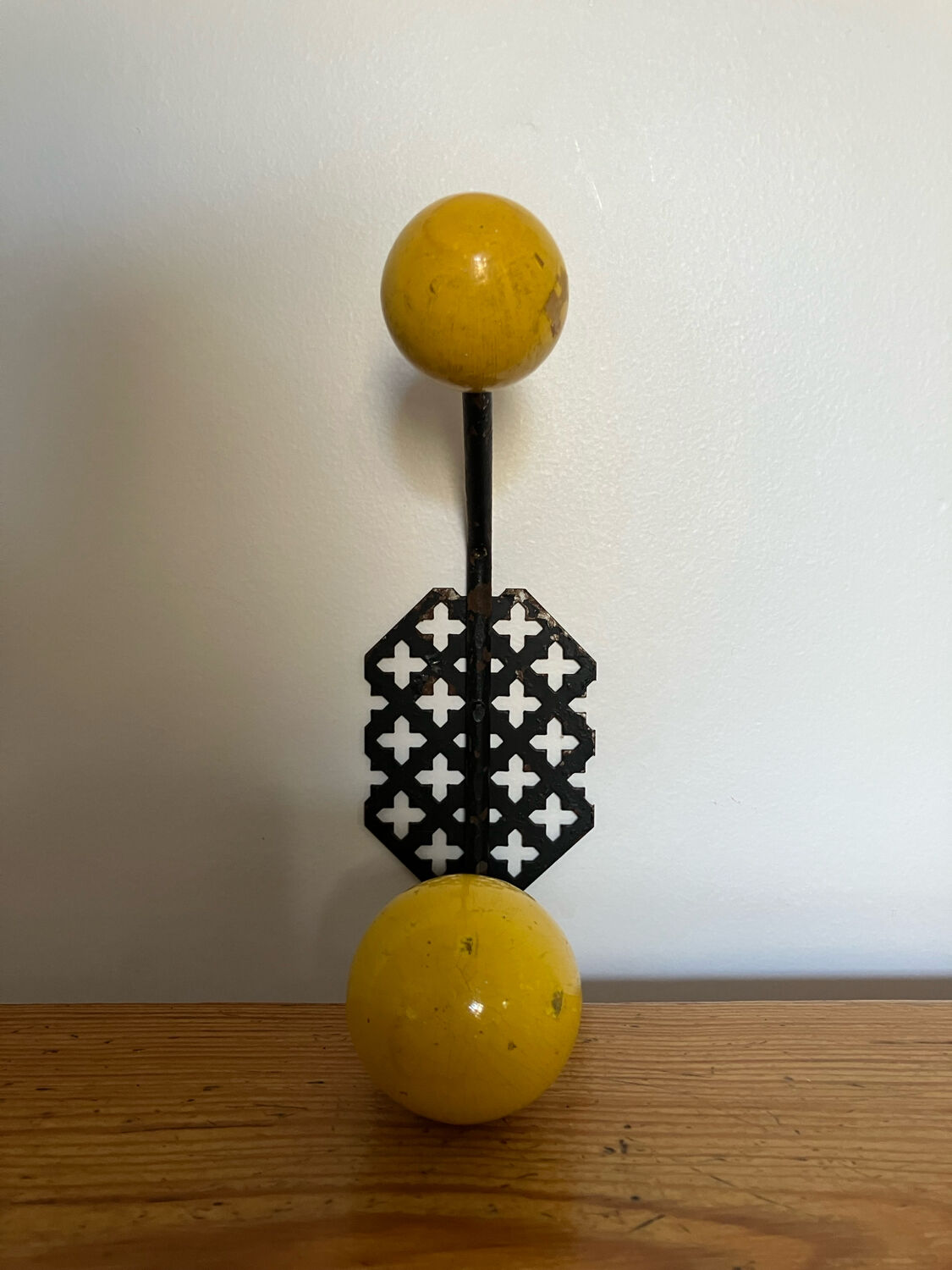 Perforated metal wall hook with yellow wooden balls, Matégot style.