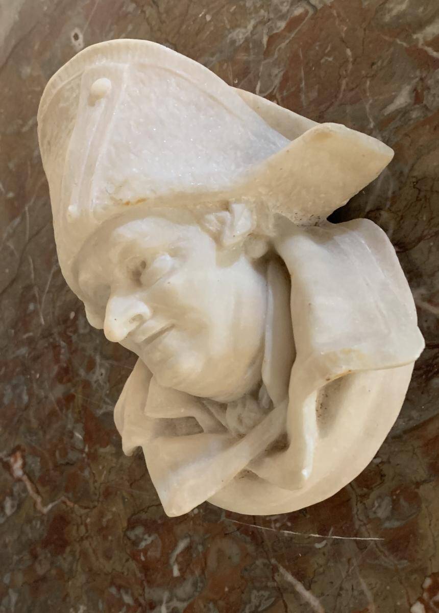 Marble sculpture, man's head in a hat.