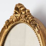 Oval giltwood mirror with rococo-style floral crest, mid-20th century