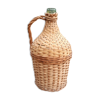 Old demijohn with handle covered with wicker