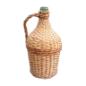 Old demijohn with handle covered with wicker