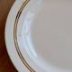 Round vintage ivory earthenware serving dish with double gold trim.