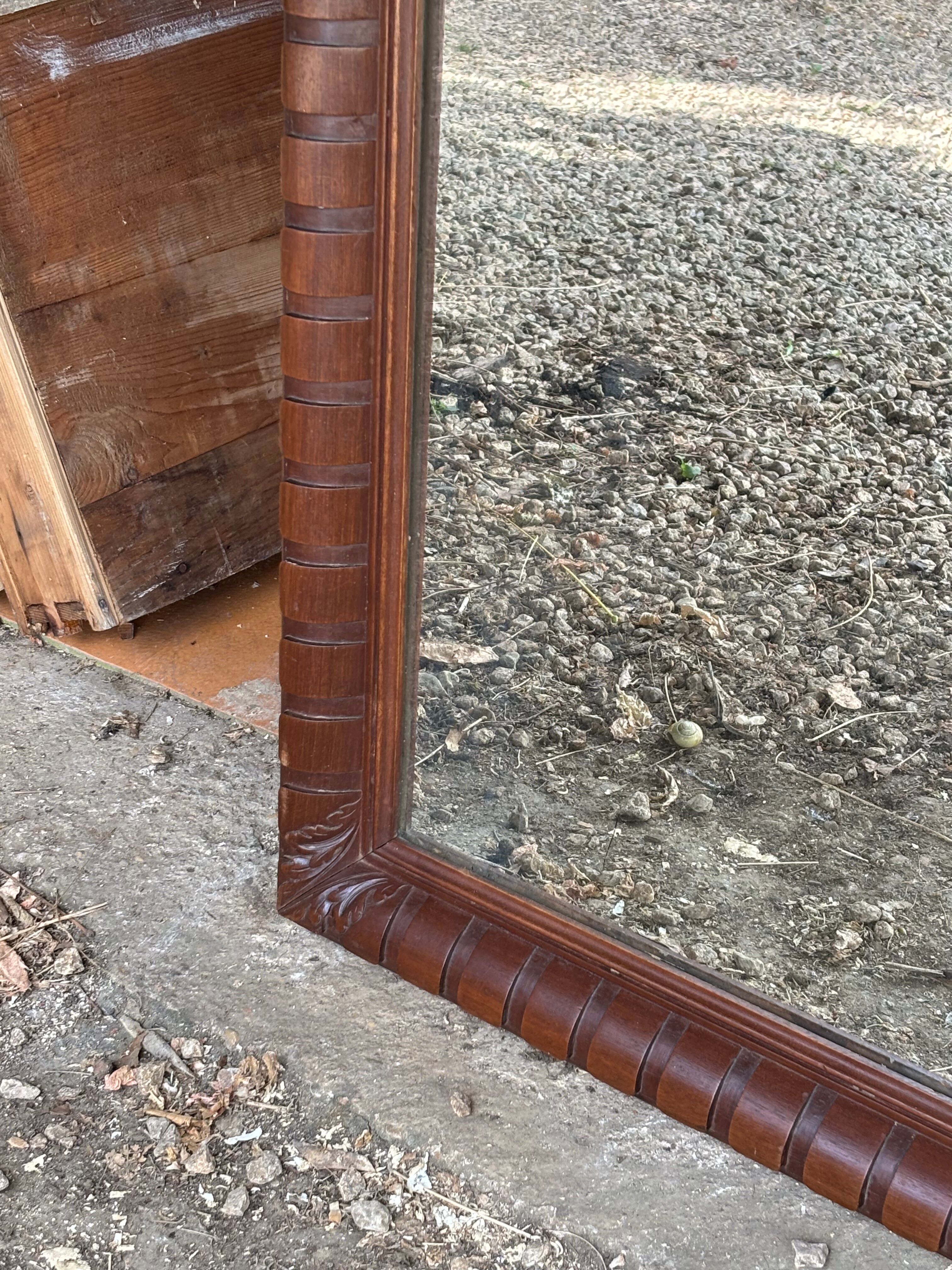 Large wall mirror with an elegant wooden frame.