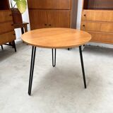 Round side table with black lacquered metal hairpin legs.