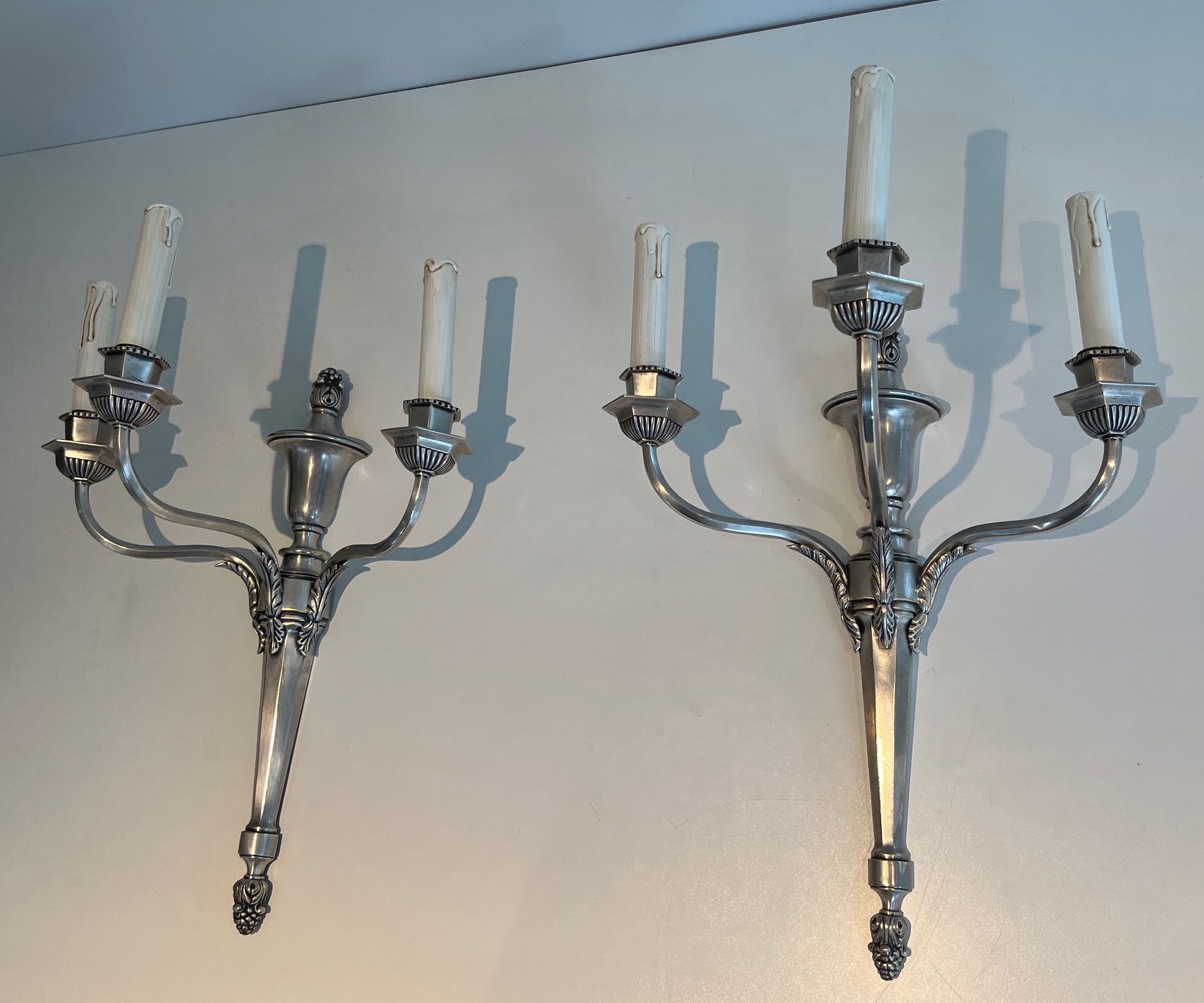 A pair of important Louis XVI style silver-plated wall sconces with three light arms.