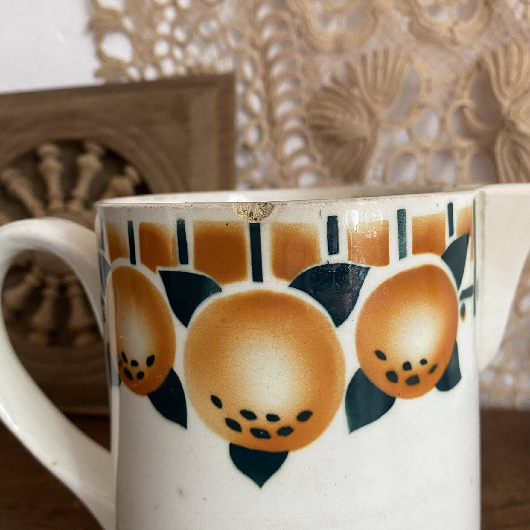 Old ceramic pitcher with orange decoration.