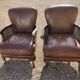 Paire de fauteuils en cuir joues en cannage