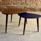 A pair of tripod and nesting coffee tables in walnut and midnight blue.